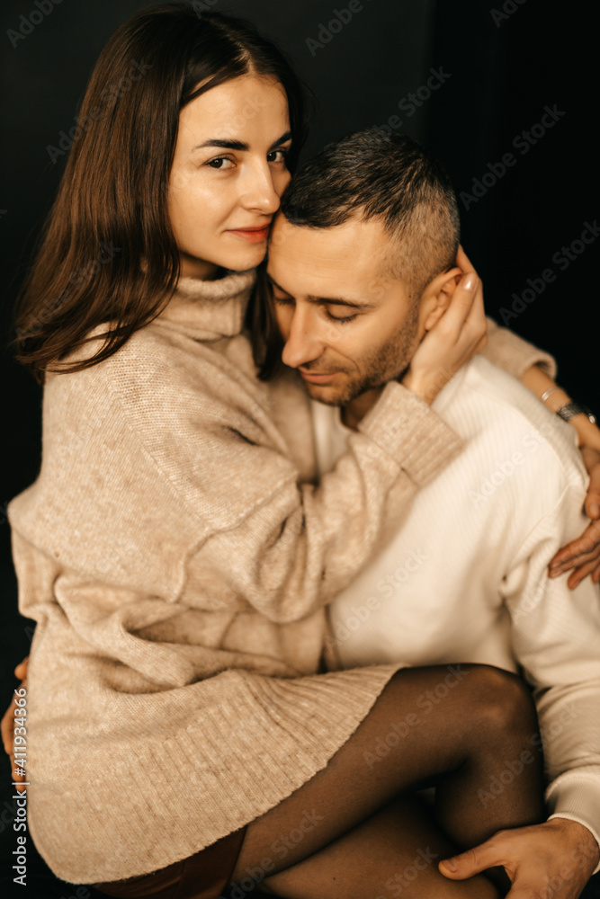 Beautiful couple cuddling while sitting on the armchair Beautiful couple cuddling while sitting on the armchair