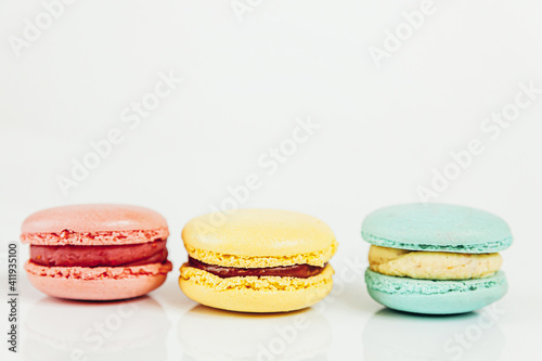 Sweet almond colorful pastel pink blue yellow macaron or macaroon dessert cake isolated on white background. French sweet cookie. Minimal food bakery concept Copy space