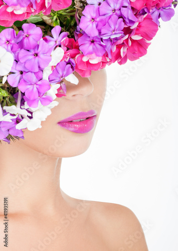 Beautiful woman with flowers in her hair. Hairstyle with flowers. Nature Hairstyle. Professional Makeup. Flower hat