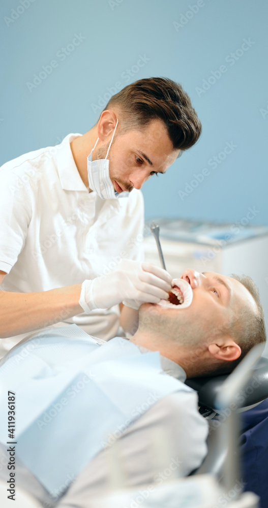 Obraz premium Dentist adjusting dental braces during orthodontic treatment for the young male patient. 4k video screenshot. Please use in small size