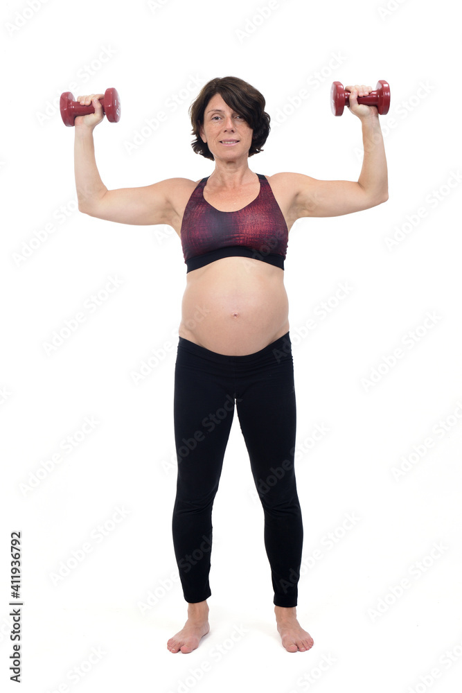 pregnant woman standing doing exercise dumbbells on white background pregnant woman standing doing exercise dumbbells on white background