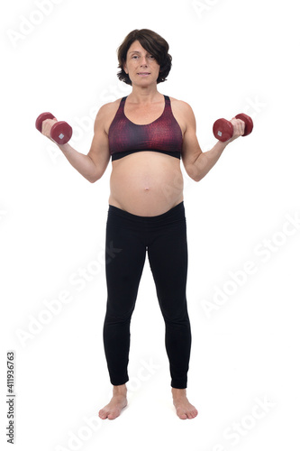 pregnant woman standing doing exercise dumbbells on white background