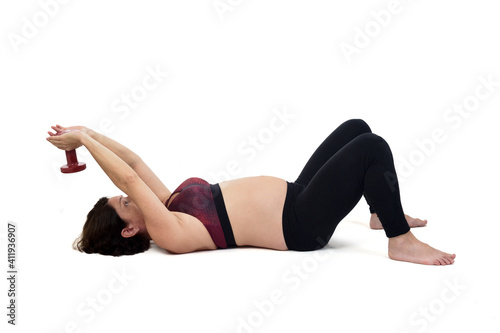 pregnant woman exercising on the floor with dumbbell on white background