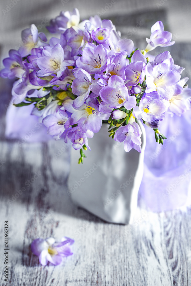 Obraz premium Freesia flowers in a vase on a table. Soft focus. Lovely bunch of flowers.