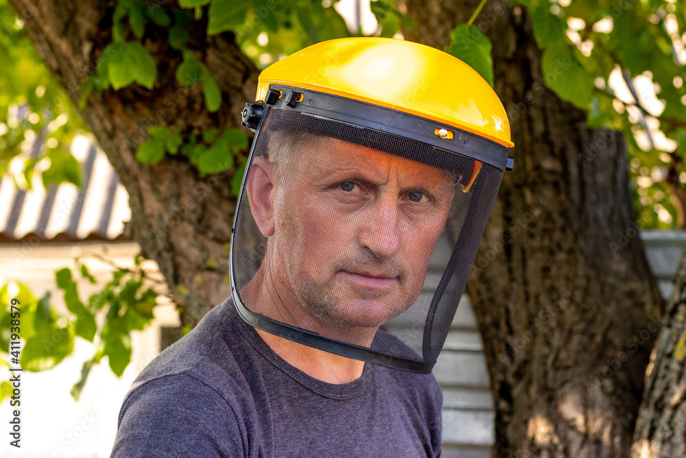A man with a protective mask for safety while mowing the grass A man with a protective mask for safety while mowing the grass