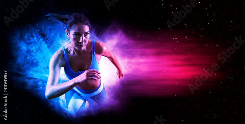 Sporty young woman running on smoke background