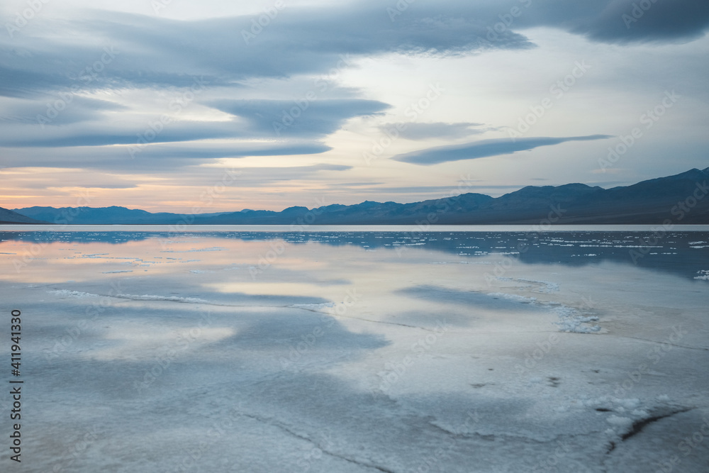 Desert landscape with wet salt field and clouds. Sunrise in Death Valley