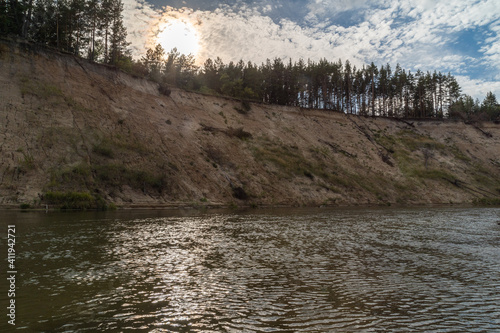 Right high bank with the dreams of the Khoper river. Sunset. The sun sets over the horizon. Rafting in the summer on a kayak on the river. Individual hike. Solo. photo