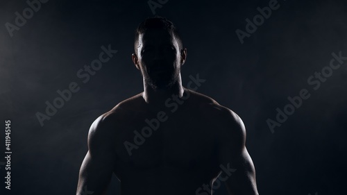 Fit and sporty bodybuilder over black background. Sportsman in studio. Sport and fitness concepts.