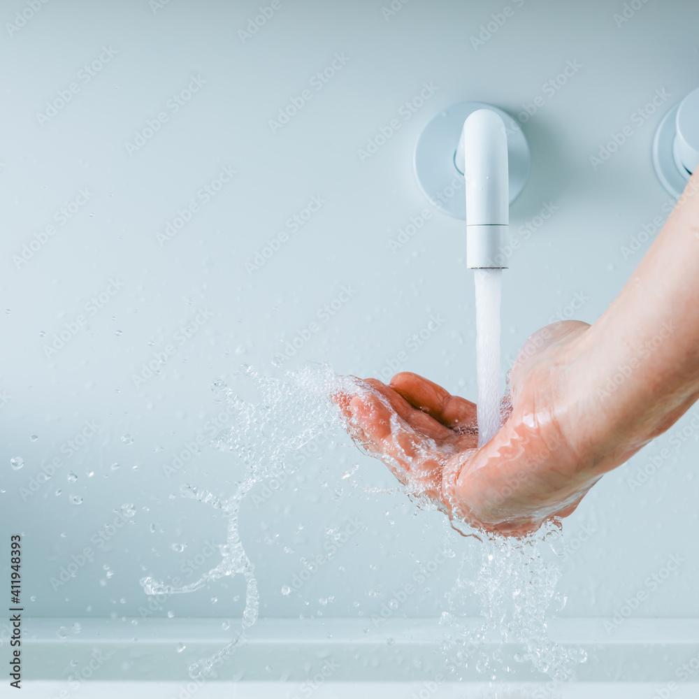Fototapeta premium hand under the faucet with flowing water splash
