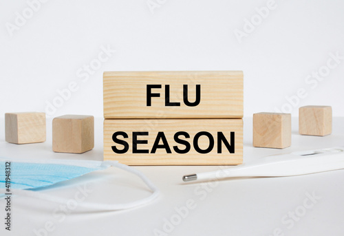 Wooden blocks with text Flu Season with mask and thermometer