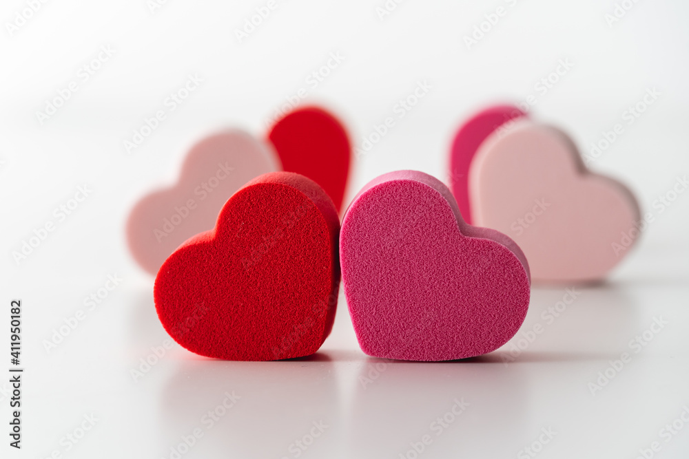 Close-up of red and pink hearts with white background.