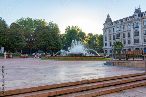 Oviedo, Principality of Asturias, Spain - September 4, 2020: Downtown cityscape, Plaza de la Escandalera, centered fountain, and the building with eclectic architecture called Casa Conde.