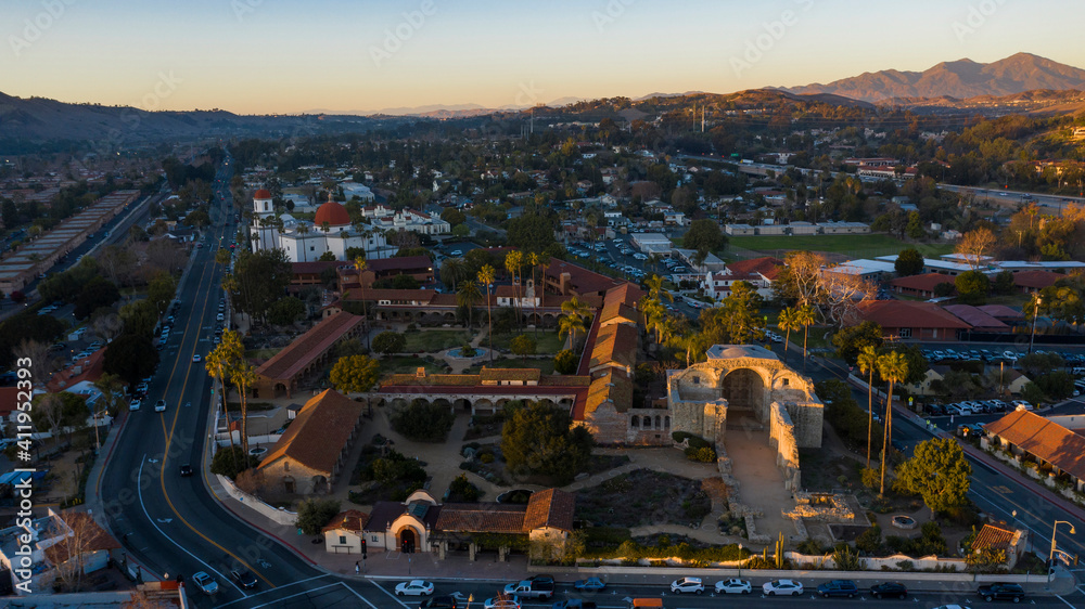 Sunset aerial view of the Spanish Colonial era mission and surrounding city of downtown San Juan Capistrano, California, USA. 