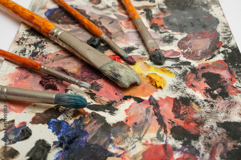 Obraz premium Paint brushes on a palette with dried paints.