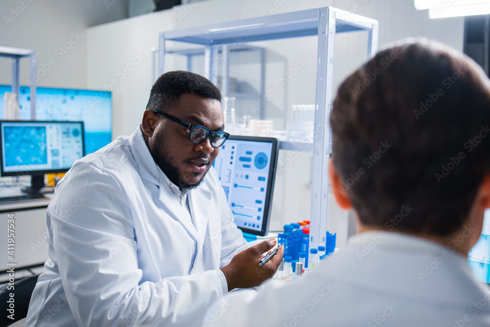 Professional team of scientists is working on a vaccine in a modern scientific research laboratory. Genetic engineer workplace. Future technology and science. Professional team of scientists is working on a vaccine in a modern scientific research laboratory. Genetic engineer workplace. Future technology and science.