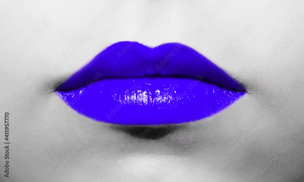 Female lips close-up with deep blue lipstick bright juicy color on a background of black and white face. Female lips close-up with deep blue lipstick bright juicy color on a background of black and white face.