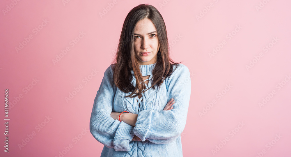 Angry emotions of a brunette girl in the studio on a pink background Angry emotions of a brunette girl in the studio on a pink background