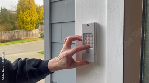 Male finger entering security code on keypad to open or close garage door of home in 4K format photo