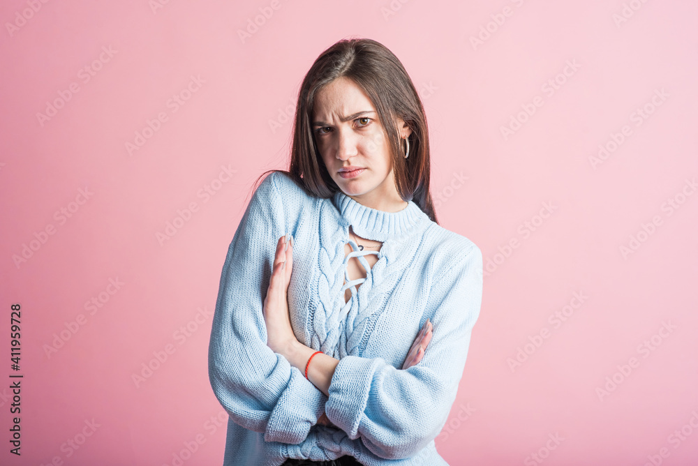 Angry emotions of a brunette girl in the studio on a pink background Angry emotions of a brunette girl in the studio on a pink background