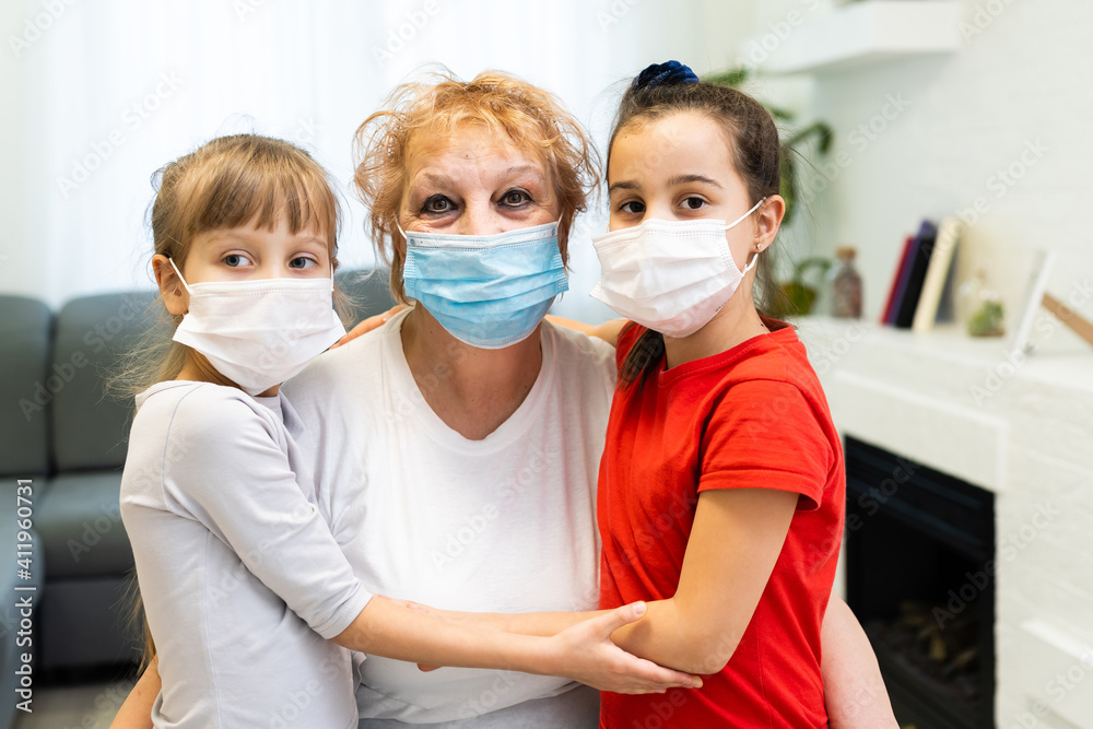 an adult woman, a retired grandmother with a granddaughters wearing a medical mask in home quarantine, because of COVID-19