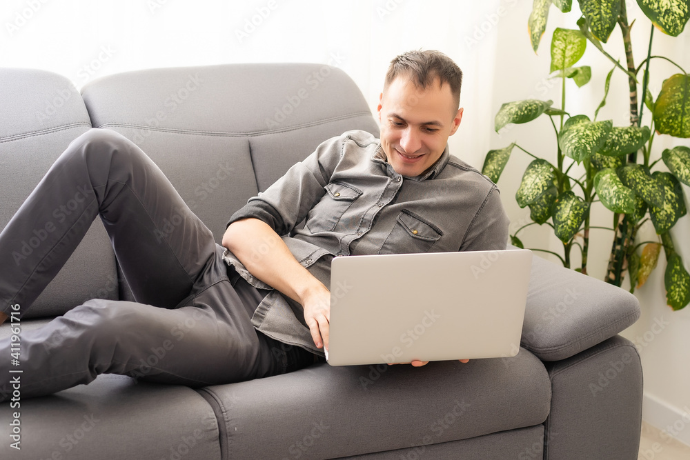 technology, home and lifestyle concept - close up of man working with laptop computer and sitting on sofa at home technology, home and lifestyle concept - close up of man working with laptop computer and sitting on sofa at home