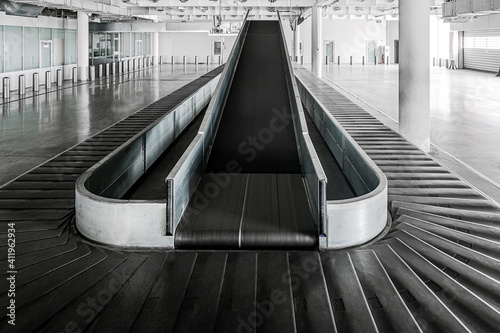 Airport terminal baggage carousel. Baggage conveyor belt in empty airport terminal. Old abandoned airport terminal.