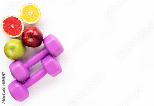 Fresh fruits for healthy eating and sports equipment (purple female kettlebells) Healthy food and sports concept