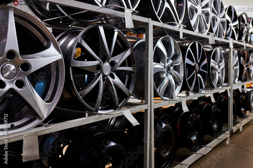 modern store with alloy wheels and tires, indoors in shop. a lot of discs for automobile, big assortment
