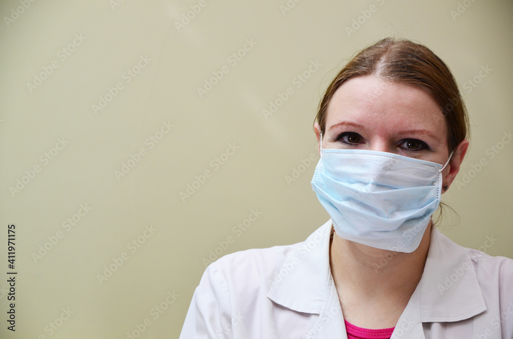 Portrait of female doctor in special surgical sterile protective clothing. puts on a mask and gloves before receiving a patient in the office Portrait of female doctor in special surgical sterile protective clothing. puts on a mask and gloves before receiving a patient in the office
