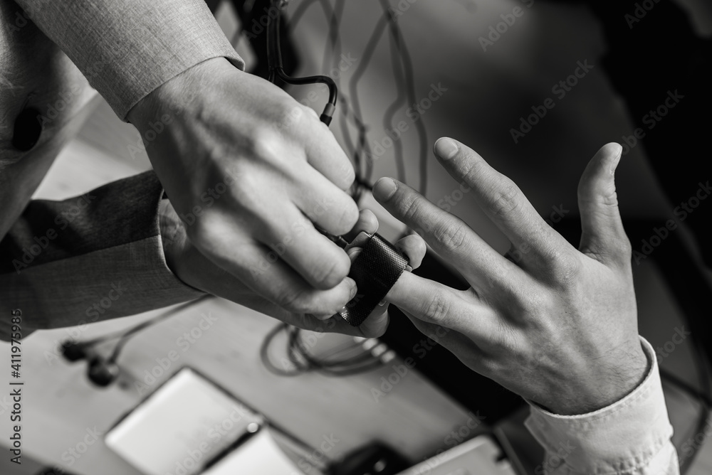 close-up, girl puts on a man's hand sensors for passing a polygraph, a truth detector. The concept of passing a polygraph