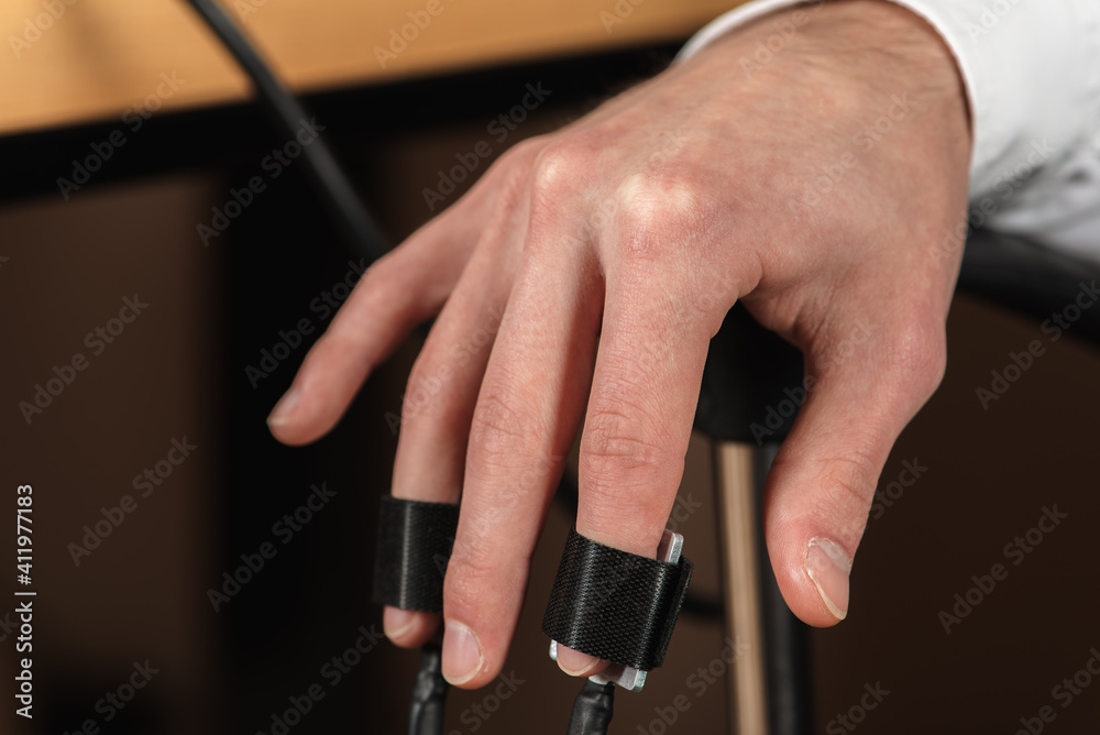 close up, on men's hands wearing polygraph sensors, truth detector for polygraph transmission, side view. Selective focus.