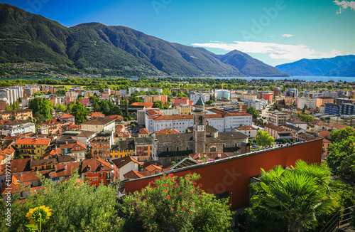 above Locarno city switzerland during summer season with blue sky and sun, green trees beautiful hdr colorful