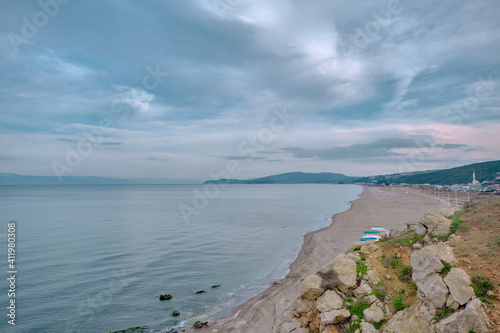 Beach  shore of marmara sea in Mudanya and small  fishing boats on the sand of beach together with small hill background during close and overcast weather.
