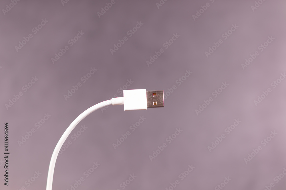curved white USB cable on gray surface background curved white USB cable on gray surface background
