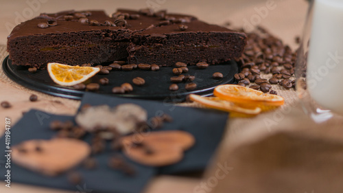 slices of chocolate brownie cake with glass of milk and coffee beanas on wooden table photo