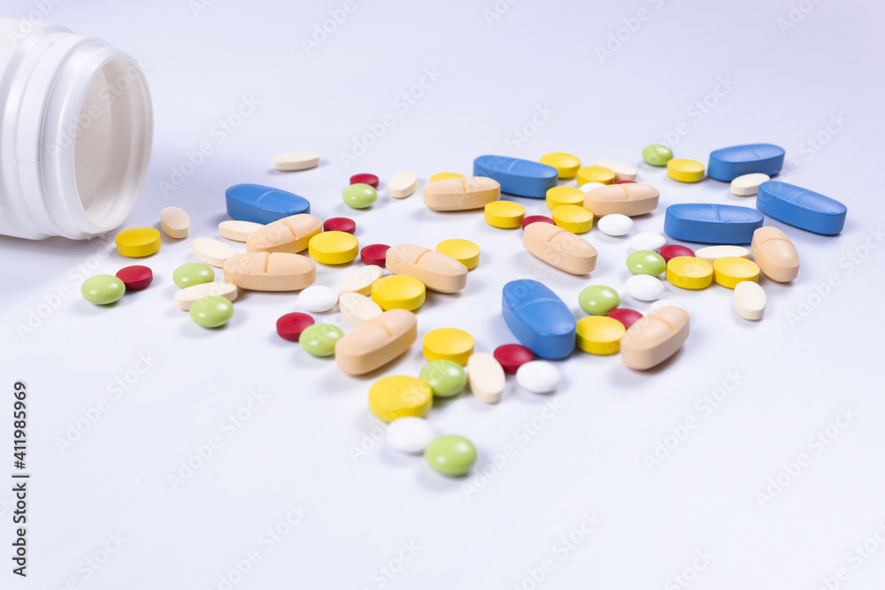 side view of multicolored pills scattered from the jar side view of multicolored pills scattered from the jar