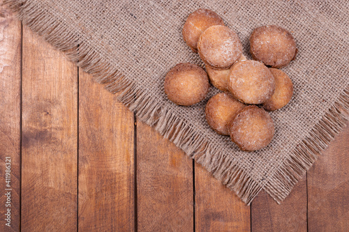 cookies stacked in a heap on a fringed rug and wooden surface, top view