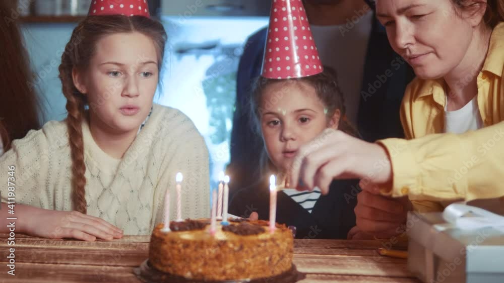 kid birthday. little girl blows out the candles on the cake in circle of happy family. celebration birthday kid concept. friendly happy family celebrating birthday a lot of people dream kid birthday. little girl blows out the candles on the cake in circle of happy family. celebration birthday kid concept. friendly happy family celebrating birthday a lot of people dream