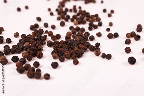 many balls of brown and black are scattered randomly on a white surface