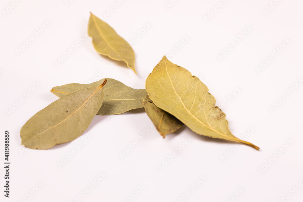 five yellow bay leaves lie side by side on a white surface