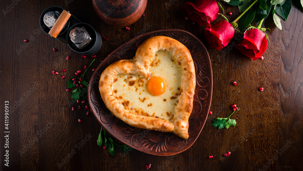Valentines Day food. Heart shaped pizza, pie with cheese and egg in the shape of a heart and Red roses on the table Valentines Day food. Heart shaped pizza, pie with cheese and egg in the shape of a heart and Red roses on the table