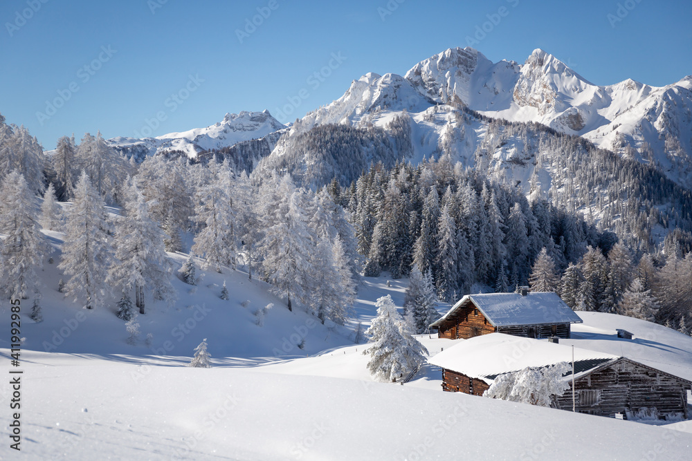 Beautiful winter mountain landscape with snowcapped wooden hut Beautiful winter mountain landscape with snowcapped wooden hut