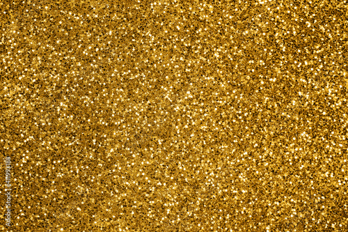 Gold defocused glitter. Bokeh light of gold glitters background. 