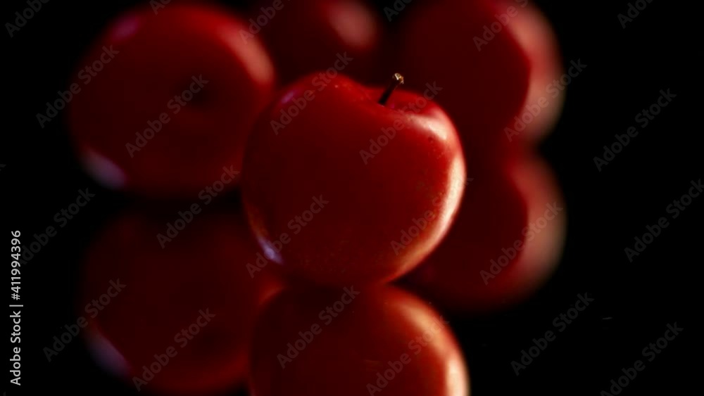 cereza roja y fresca sobre fondo negro , cae agua sobre ella; fruta con reflejo inferior. sin sonido