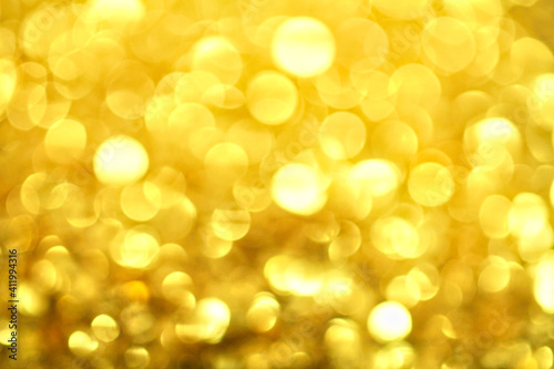 Gold defocused glitter. Bokeh light of gold glitters background. 