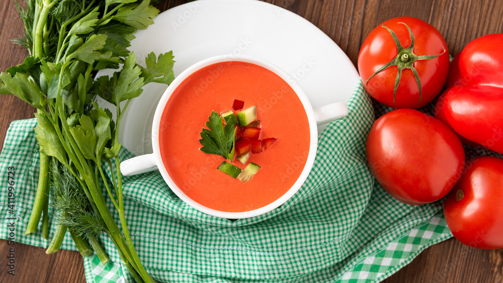 Delicious cream soup of tomatoes on a wooden background with herbs and croutons. In a soup bowl. Delicious cream soup of tomatoes on a wooden background with herbs and croutons. In a soup bowl.