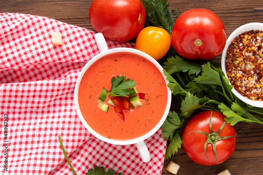 Spanish tomato gazpacho soup made from fresh tomatoes with various spices and herbs on a wooden background. Spanish tomato gazpacho soup made from fresh tomatoes with various spices and herbs on a wooden background.