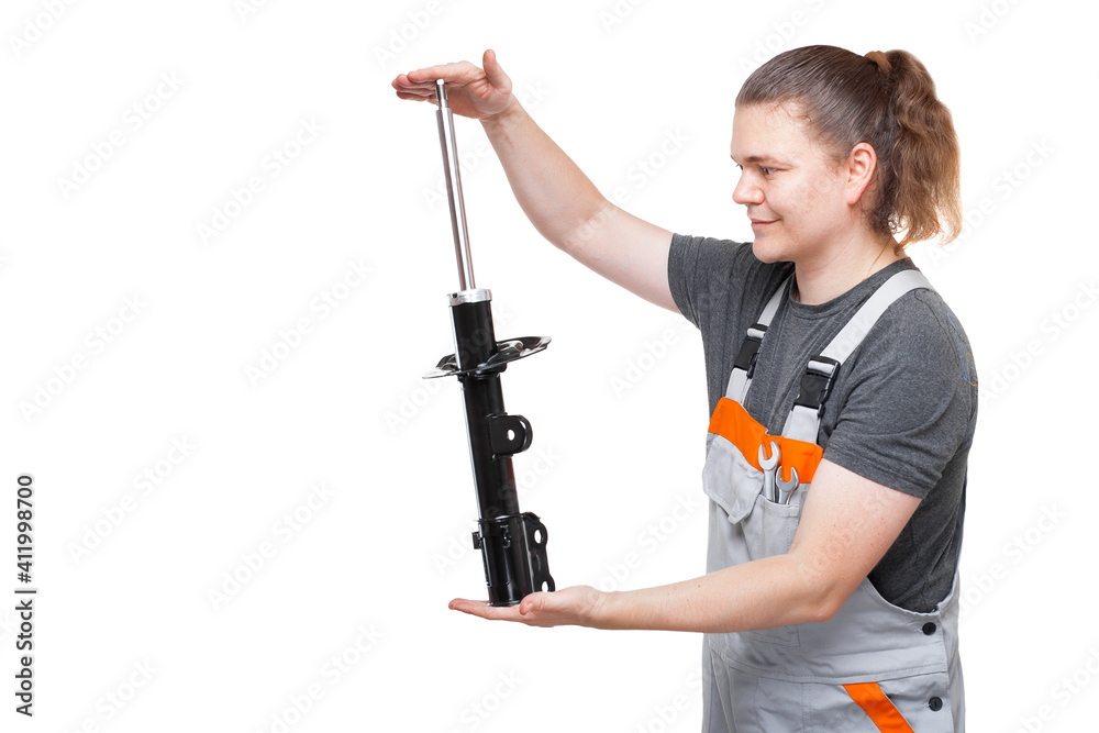 car mechanic in gray uniform with spanner wrench in pocket is holding in his hands car spare part of suspension system front shock absorber isolated on white background with copy space. car mechanic in gray uniform with spanner wrench in pocket is holding in his hands car spare part of suspension system front shock absorber isolated on white background with copy space.
