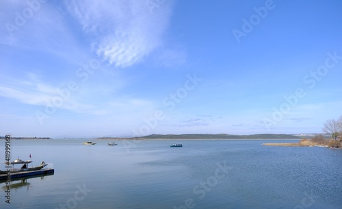 Magnificent sky and cloud shape on the lake of Uluabat town in Bursa. Boats on the lake part of town observing from photo.